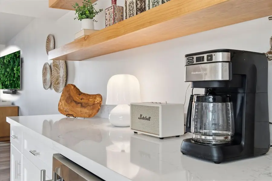 Coffee bar close-up at Hideaway with a drip coffee maker, a Marshall speaker and open wood shelving