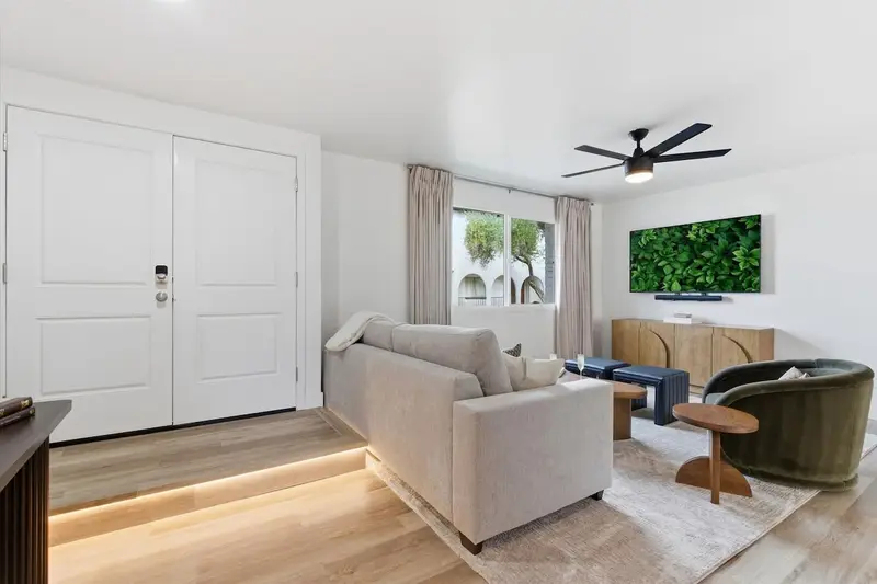 Front entry of Hideaway: white double doors opening to the living room, with a lit step and the sectional