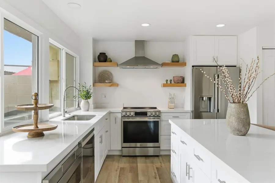 Kitchen sink under the windows, five-burner stainless range and full-size refrigerator at Hideaway