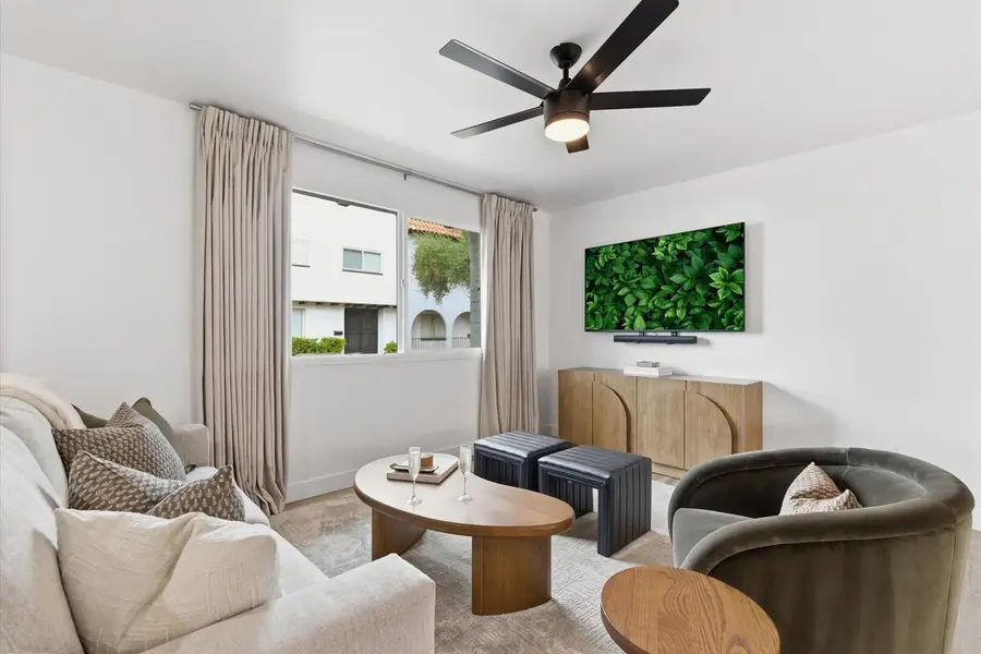 Living room at Hideaway with the 65-inch smart TV above a wood console, a sofa and a velvet armchair