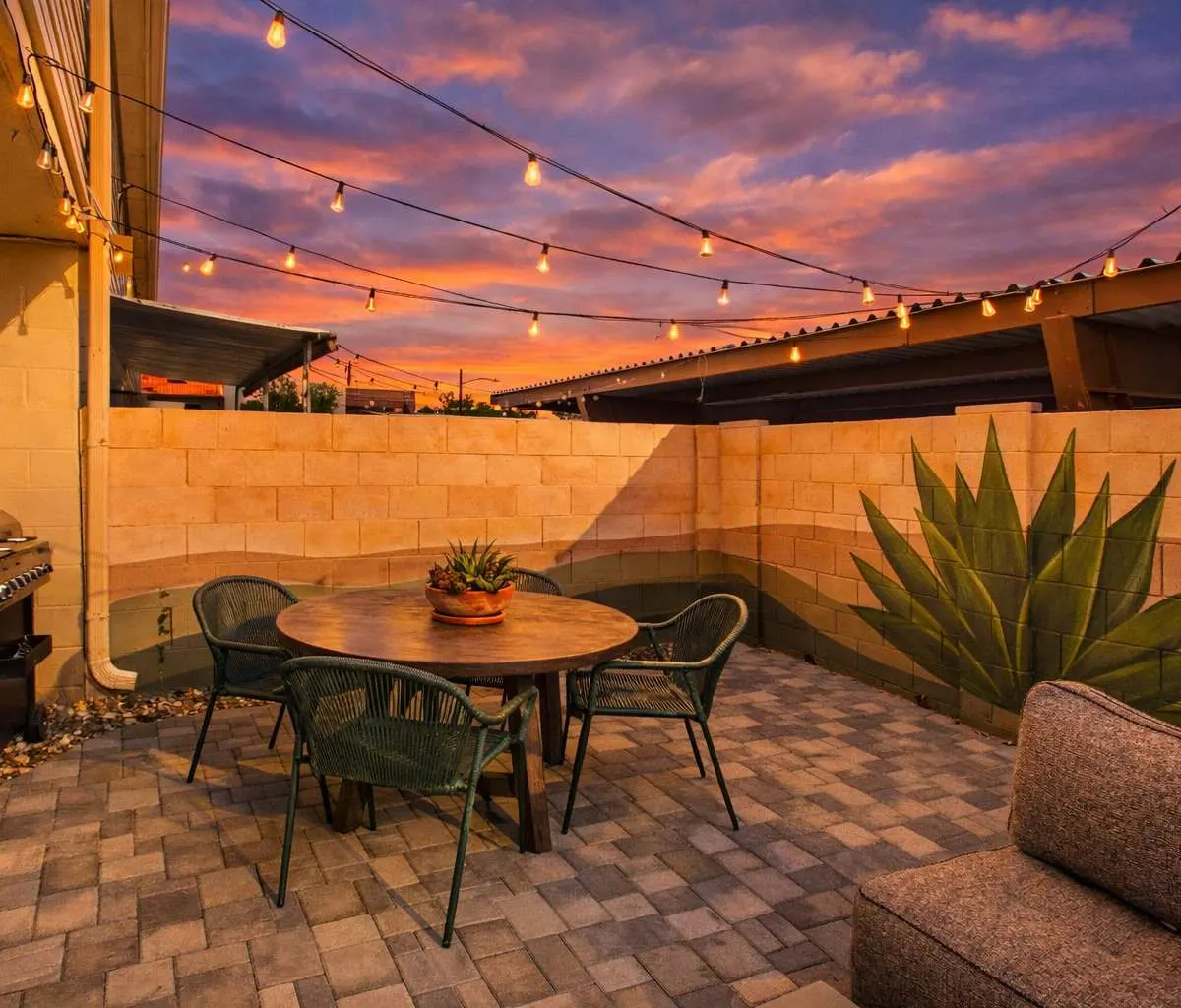 Patio dining table, gas grill and agave at Hideaway with the desert mural painted along the block wall
