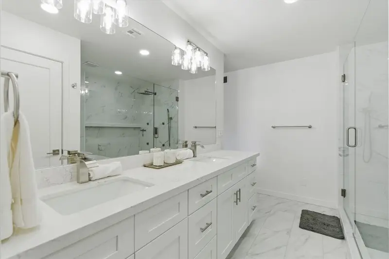 Primary bathroom at Hideaway with a dual vanity, walk-in shower and bathtub